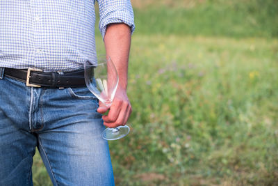 Midsection of man holding grass