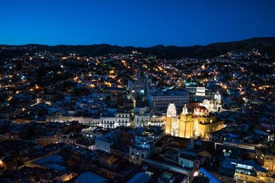 High angle view of illuminated cityscape against sky at night