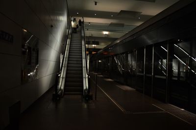 Rear view of people on escalator in subway station