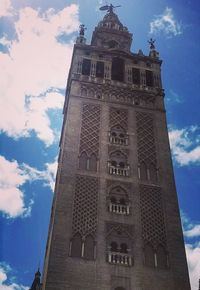 Low angle view of bell tower against cloudy sky