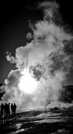 Tourists standing near natural geyser