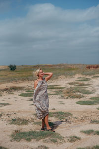 Full length of woman standing at beach against sky