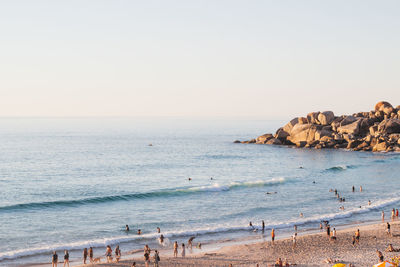 People enjoying at beach against sky