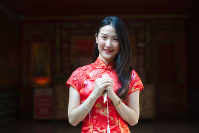 Portrait of young woman wearing red traditional clothing while standing outdoors