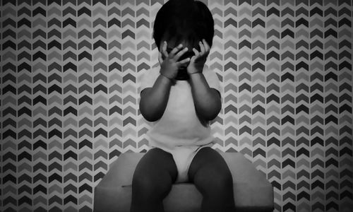 Midsection of woman sitting against wall