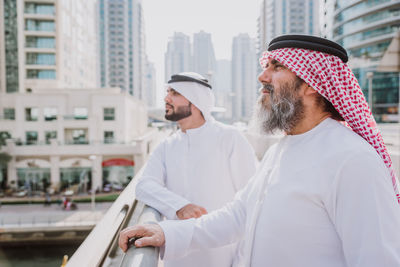 Friends standing by buildings in city