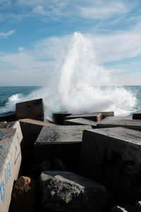 Waves splashing on sea against sky