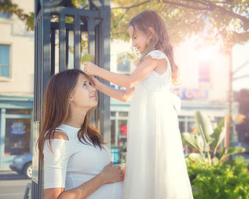 Side view daughter playing pregnant mother at park