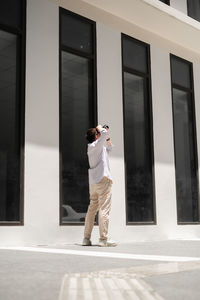 Man photographing building while standing outdoors