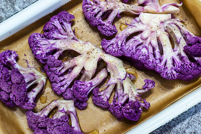 Purple cauliflower in a white baking dish in the oven