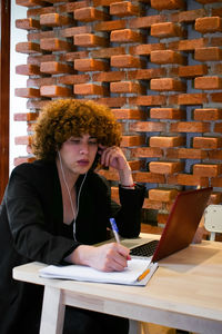 Businesswoman using laptop while sitting on table