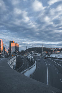 Road amidst buildings in city against sky