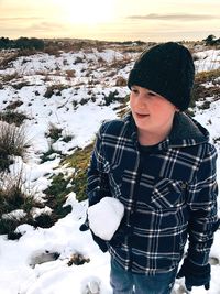 Close-up of boy standing on snow during winter