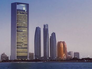 City at waterfront against clear sky