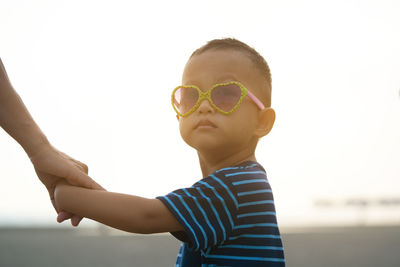 Portrait of boy wearing sunglasses against sky
