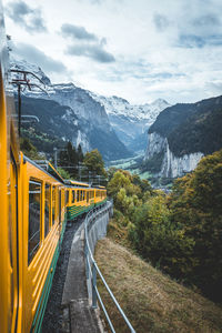 Train near mountain range against sky