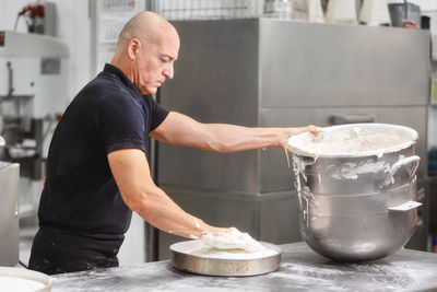 Side view of man preparing food in kitchen