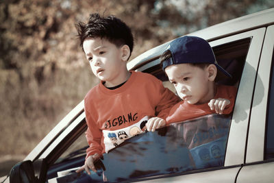 Boy looking away while sitting in car