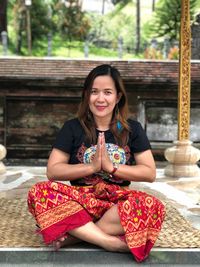 Portrait of a smiling young woman sitting outdoors