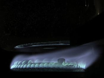 Close-up of illuminated light bulb against black background