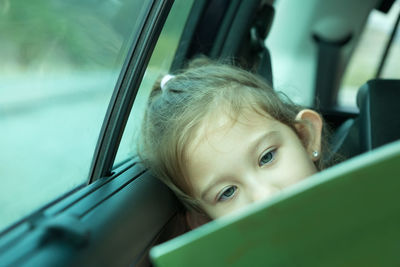 Cute girl reading book in car