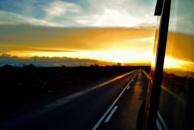 Road seen through window during sunset