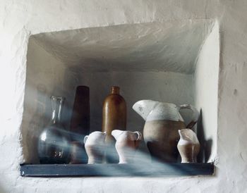 Close-up of bottles on shelf against wall