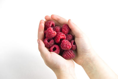 Midsection of woman holding fruit against white background