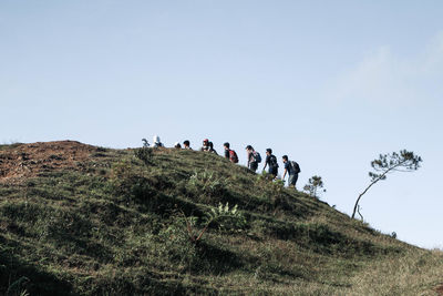 Group of people on mountain against sky