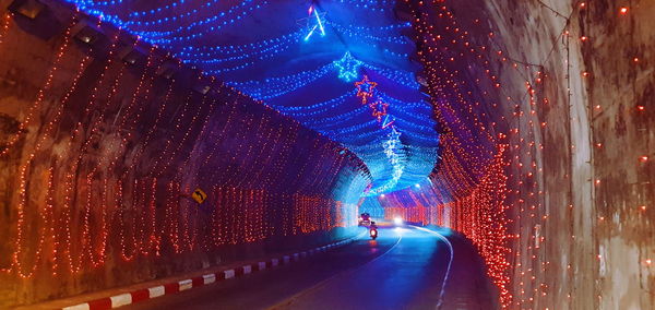 Low angle view of illuminated lights in tunnel