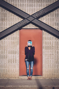 Woman standing by wall