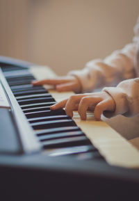 A little girl plays the electric piano.