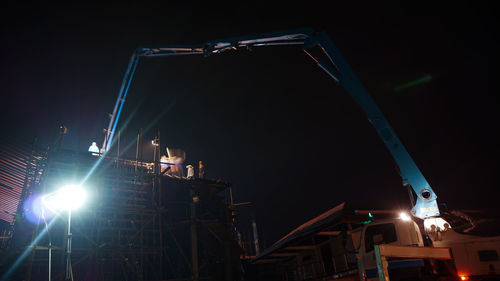 Low angle view of illuminated construction site at night