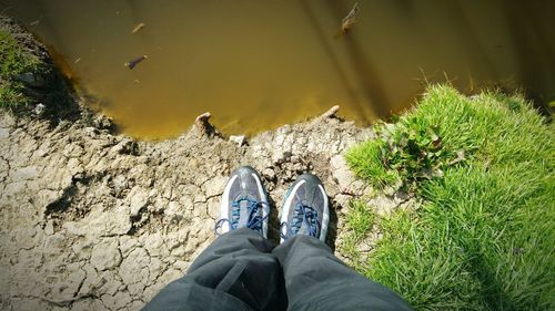 Low section of man standing by pond