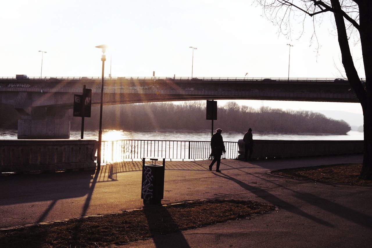 PEOPLE WALKING ON ROAD AGAINST CLEAR SKY