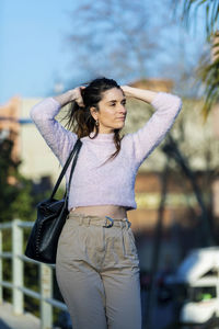 Woman looking away while standing in city