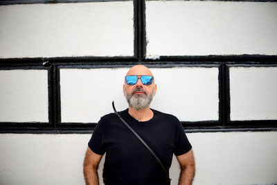 Portrait of man standing against wall
