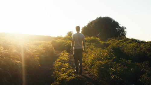 Boy walks at sunset in a plain in the mountains