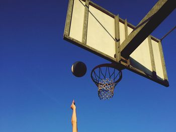 Low angle view of basketball hoop against clear blue sky