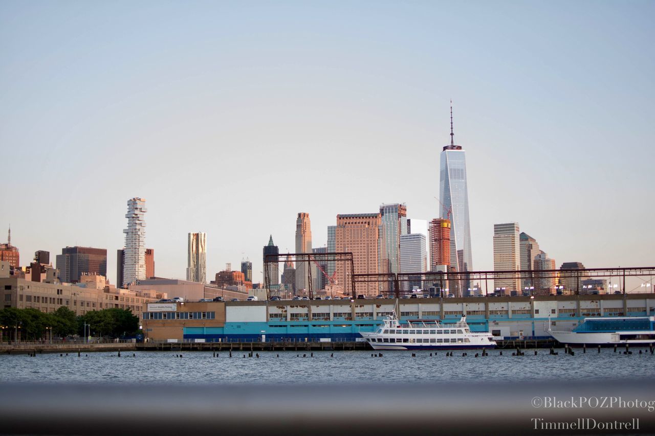 architecture, skyscraper, building exterior, tower, tall - high, built structure, city, cityscape, urban skyline, waterfront, modern, clear sky, travel destinations, no people, day, water, sky, outdoors, tall