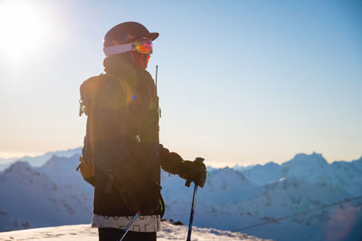 Side view of a snowboarder or skier against the backdrop of mountains at a ski resort in bright