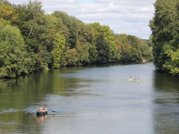 People in boat on lake against trees