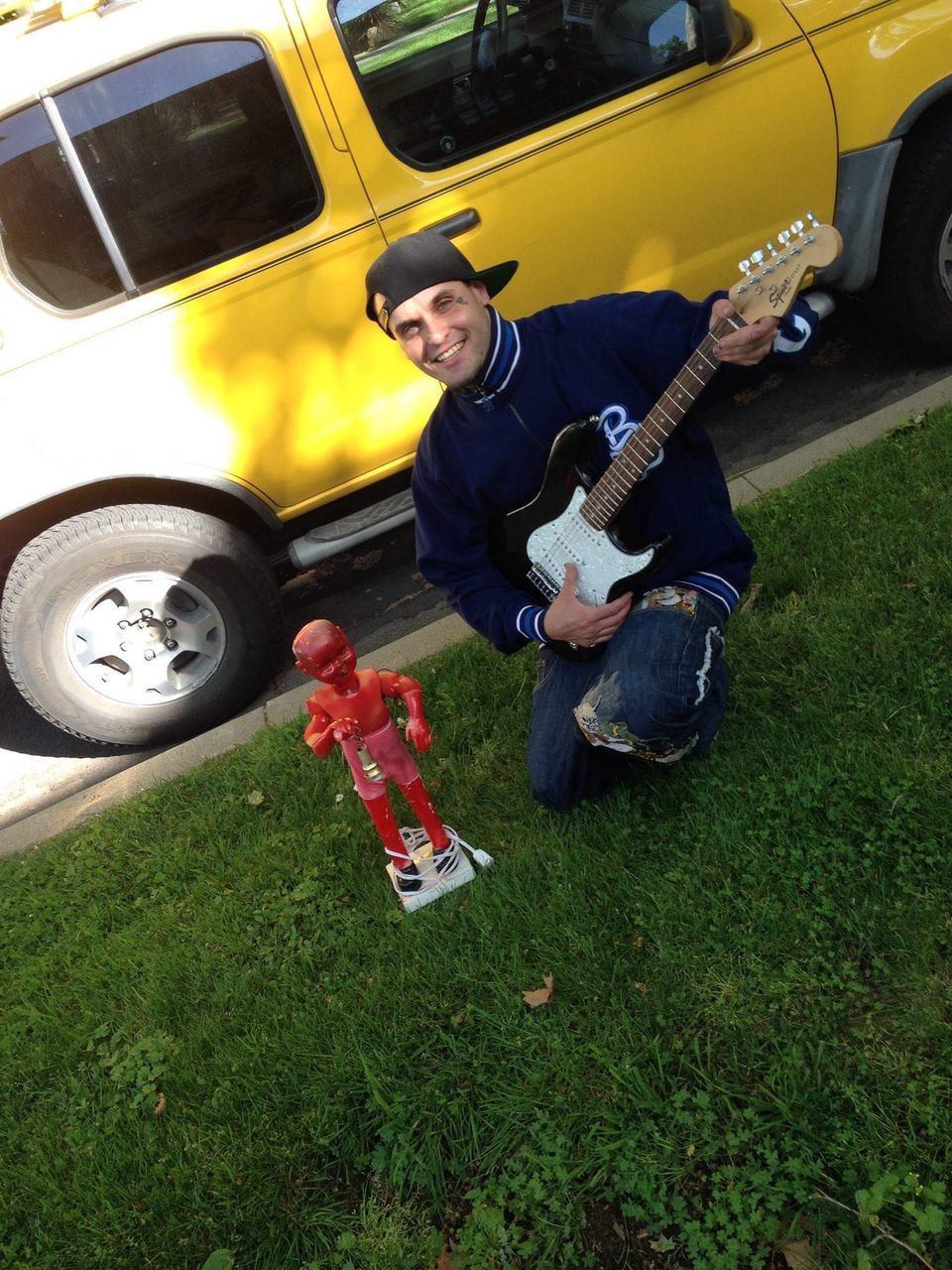 YOUNG MAN PLAYING GUITAR ON THE ROAD