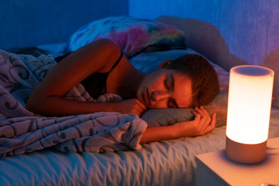 Young beautiful woman sleeping in a bed in the bedroom with a soft toy