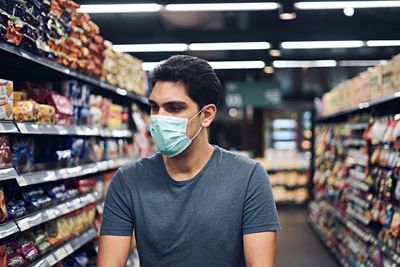 Portrait of young man standing in store