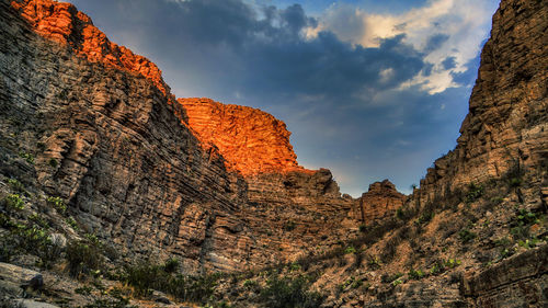 Low angle view of rocky mountains against sky