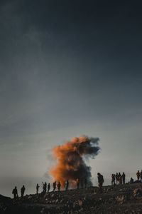 Group of people enjoying on land against sky