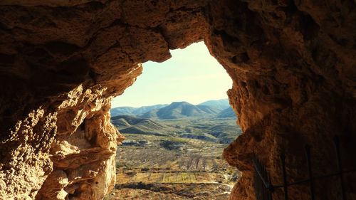 Scenic view of mountains seen through cave