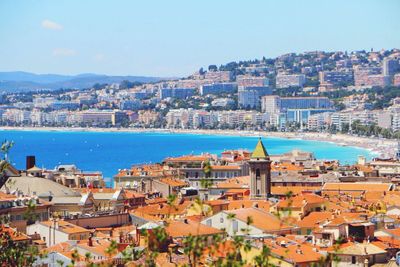 High angle view of cityscape by sea against clear sky