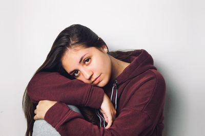 Portrait of young woman against white background